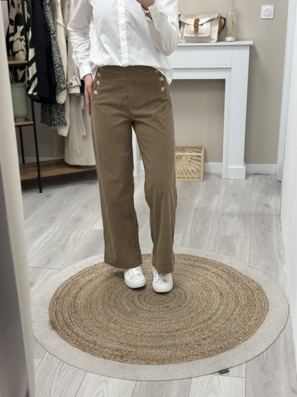 Femme portant un pantalon velours camel et boutons