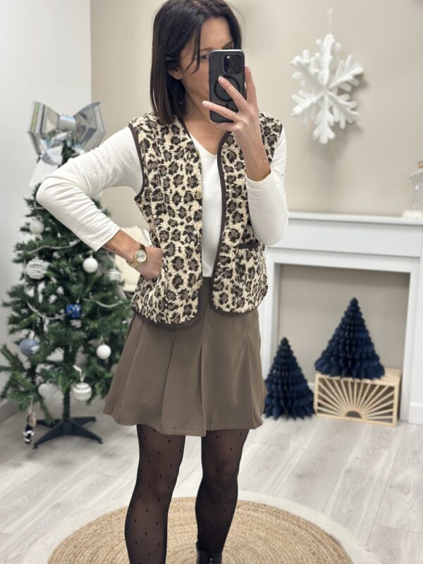 Femme portant un gilet moumoute leopard et une jupe chocolat